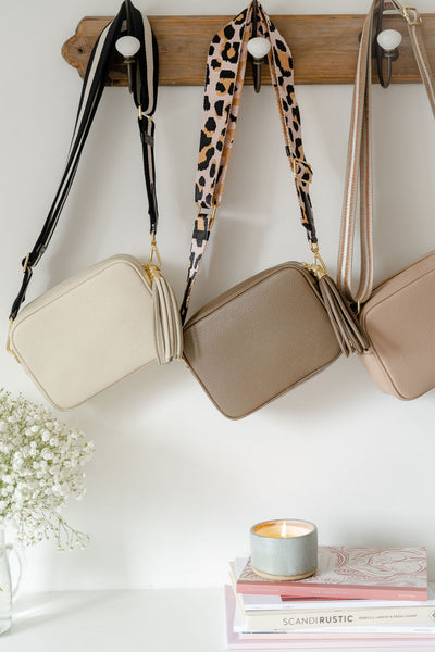 cream, taupe and rose pink leather bags hanging up