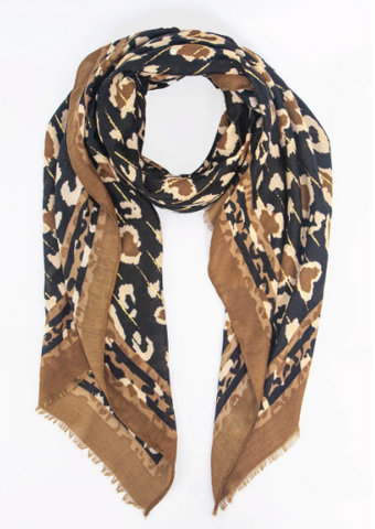 A scarf with a mixed camel and stone leopard print with gold highlights on a black background, with a striped edge.
