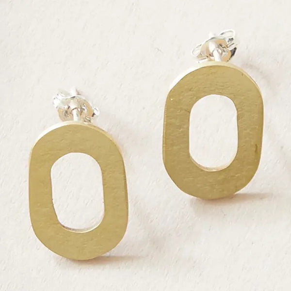 Gold hoop stud earrings on a light beige background