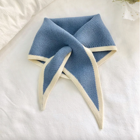 Blue and white knitted scarf on a white surface