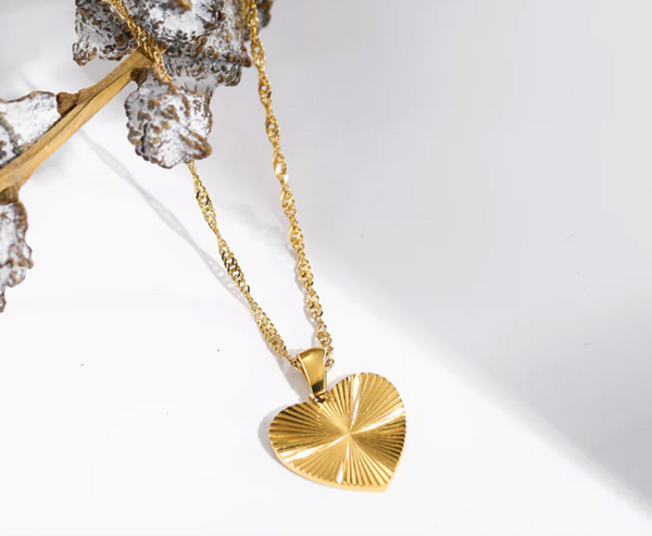 Gold heart-shaped pendant necklace on a white background