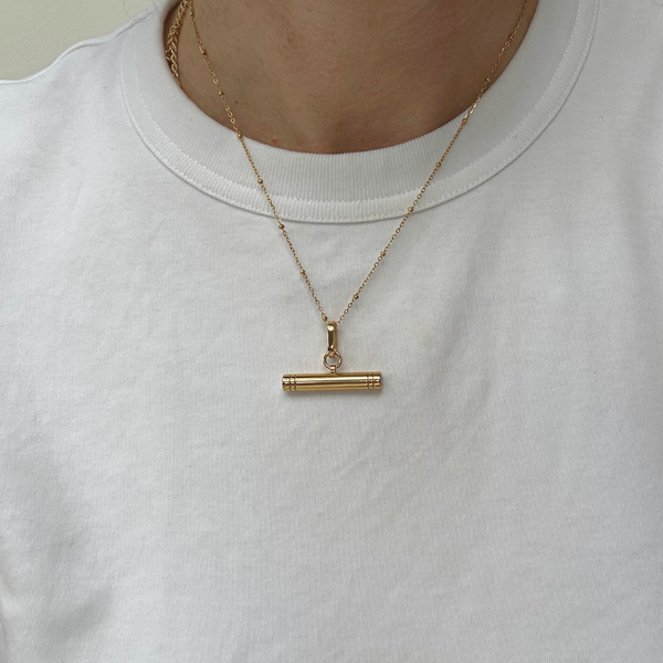 woman in white t-shirt with a gold T-bar necklace
