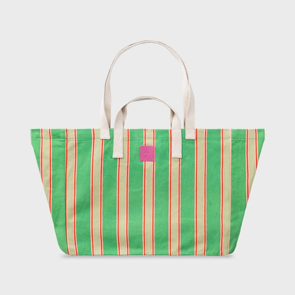 Green striped tote bag with a pink tag on a light gray background
