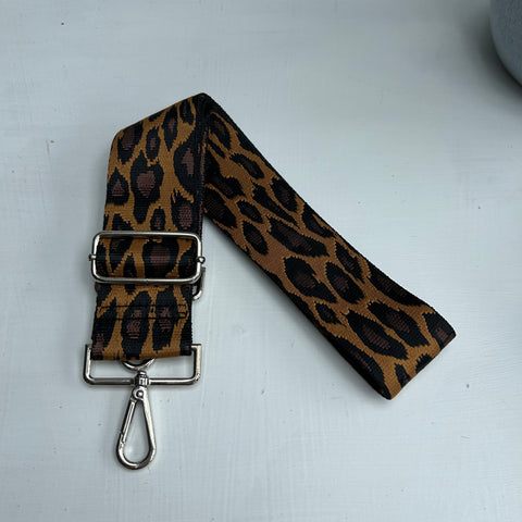 Leopard print strap with metal clip on a white background