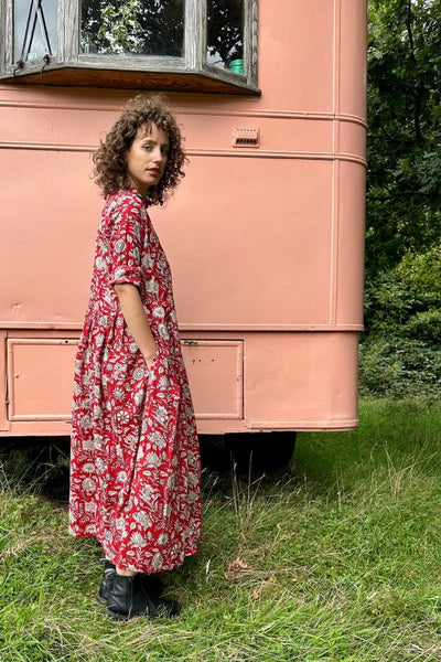 women in red shirt dress standing on grass