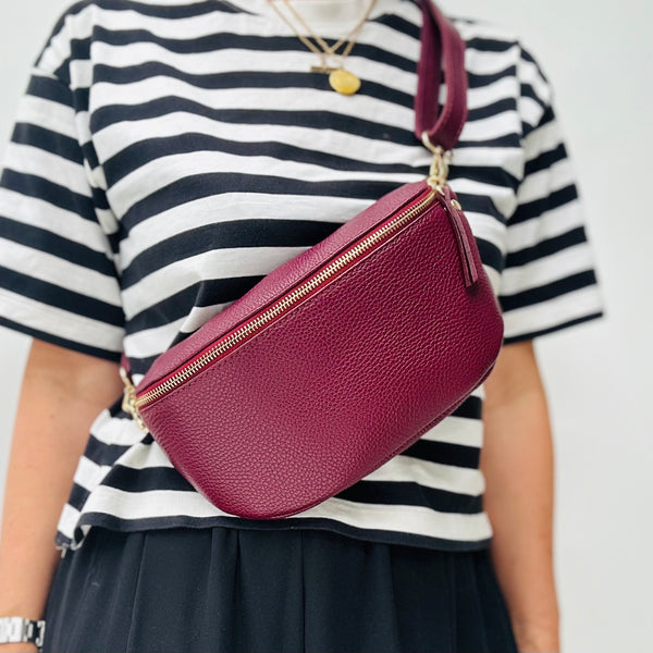 Cathy in a black and white striped teewith a burgundy leather crossbody bag.