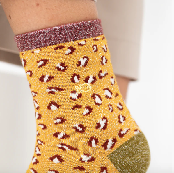Yellow sock with leopard print pattern worn by a woman