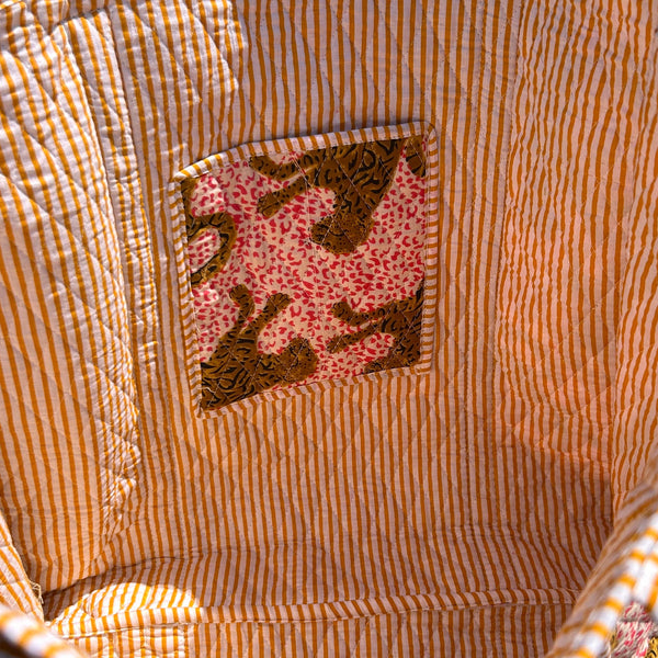 Close-up of a fabric pocket and striped bag lining. 