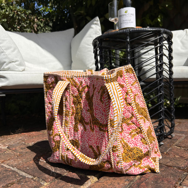 Leopard pring cotton tote bag on a stone surface with a bottle of wine in the background