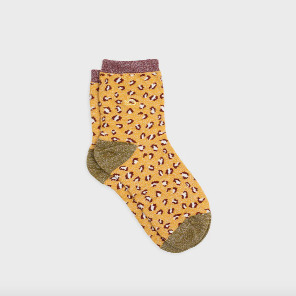 Yellow sock with leopard print pattern on a light gray background