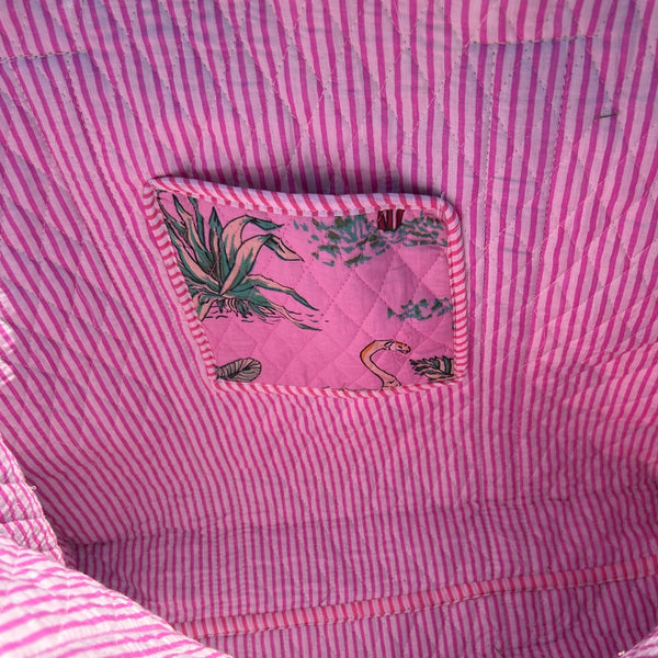 Pink striped fabric with a small pocket featuring a design.