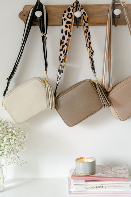 cream, taupe and rose pink leather bags hanging up