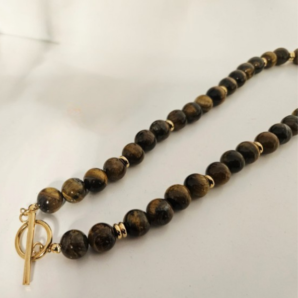 Tiger's eye quartz Beaded necklace with a gold clasp on a light background