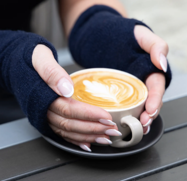 Turtle Doves Recycled Cashmere Wristwarmers - navy Blue worn by model with a coffee