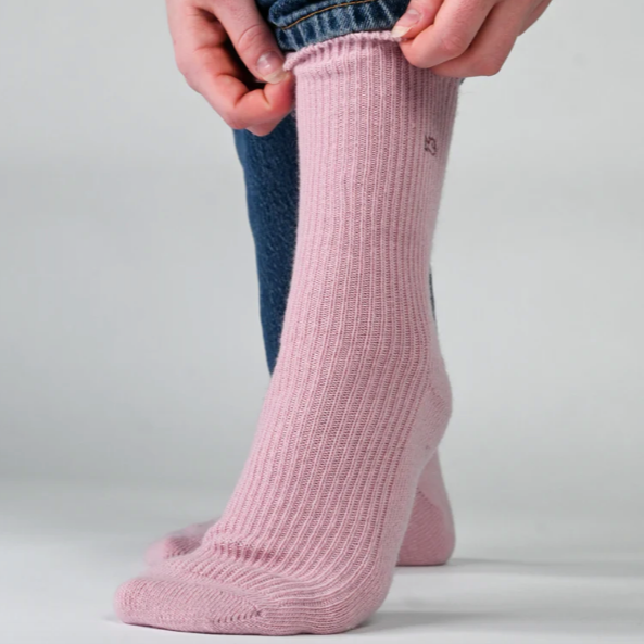 pale pink socks worn by a women with blue jeans against a white background