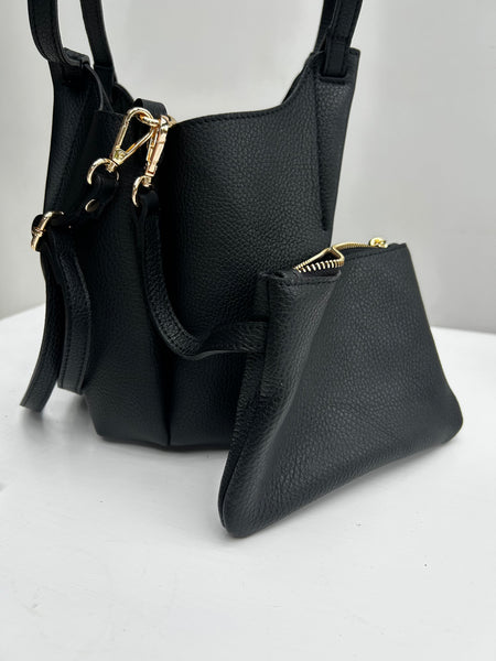 black leather handbag with an internal leather pouch on a white table