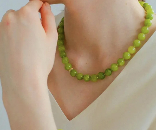 woman in a white blouse wearing a Green quartz beaded necklace 