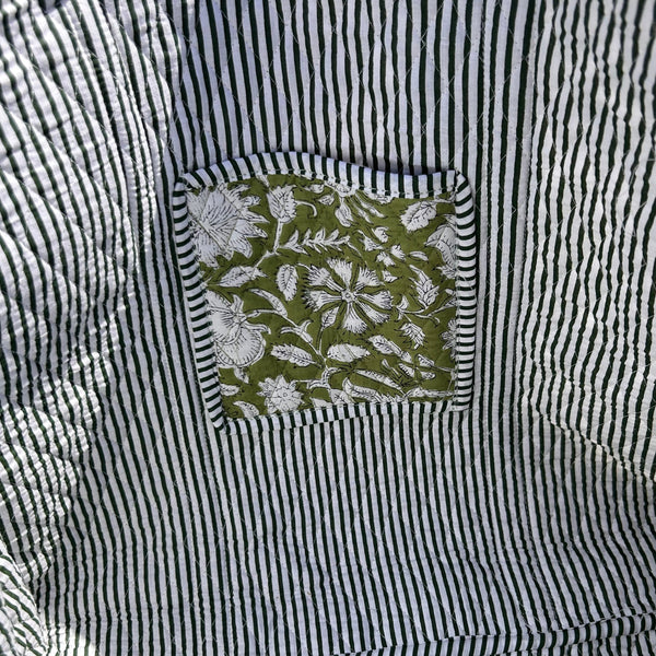 Green and white bag lining with a green floral pocket .