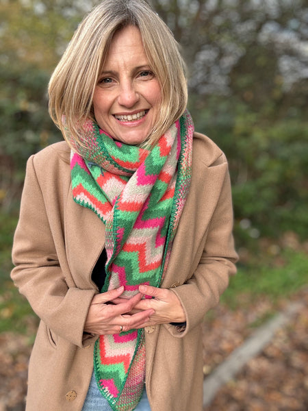 Woman wearing a colorful scarf and beige coat outdoors