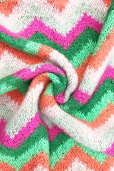 Close-up of colorful fabric with pink, green, and white zigzag pattern
