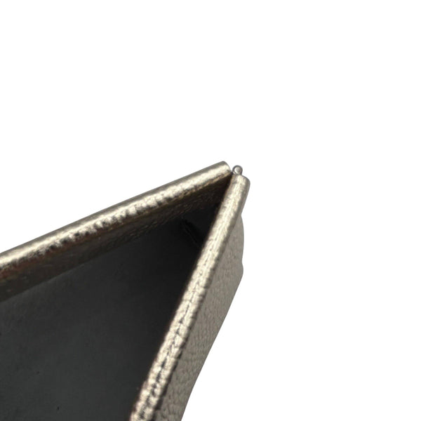 Close-up of inside a textured metallic leather  pouch on a white background