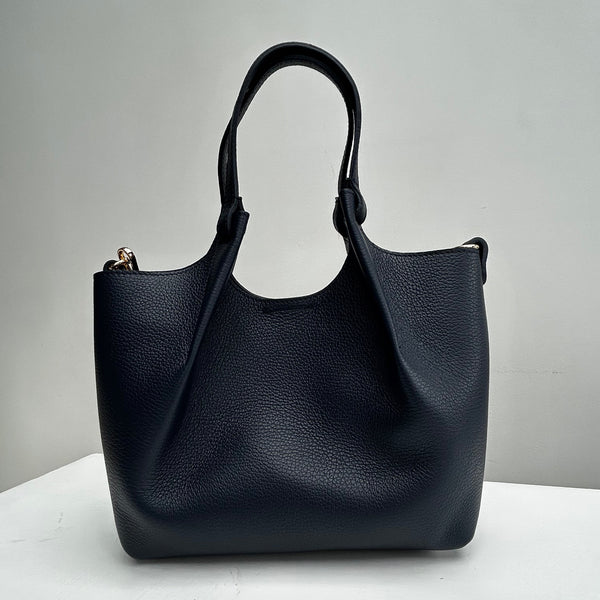 navy leather bag with top handles on a white table