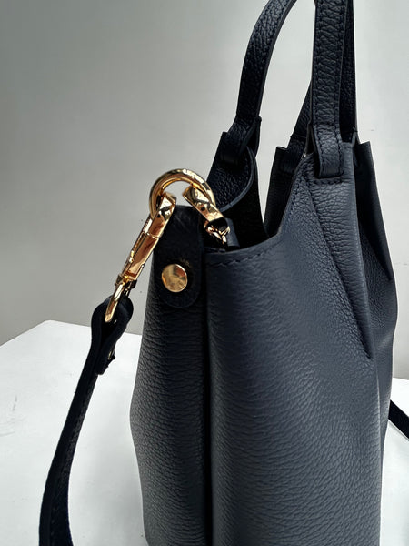 close up of gold hardware on a navy leather bag