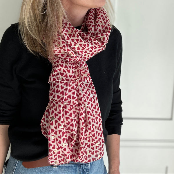 Woman wearing a red and white patterned scarf against a white background