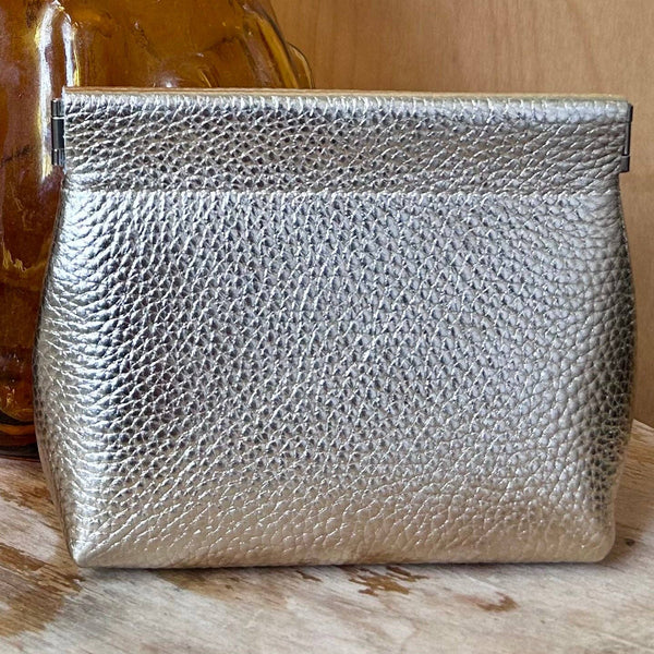 gold leather textured clutch bag on a wooden surface