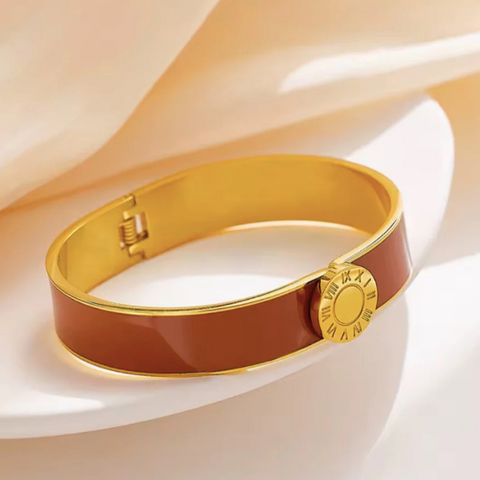 Gold and brown bracelet with a gold clasp on a white surface