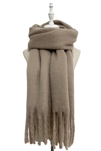 Taupe soft blanket scarf with long tassels on a mannequin on a white background