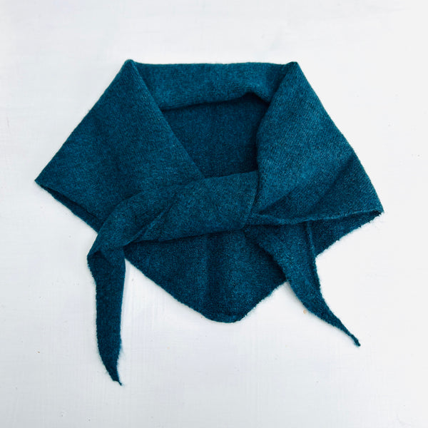 Teal wool scarf in a knot on white background